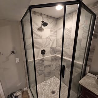 Custom tile shower with glass enclosure by Hammer Down Construction